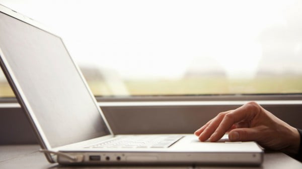 Close up of a woman's hand on laptop computer on a passenger train. (Design Pics via AP)