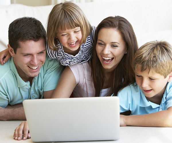 Young parents, with children, on laptop computer